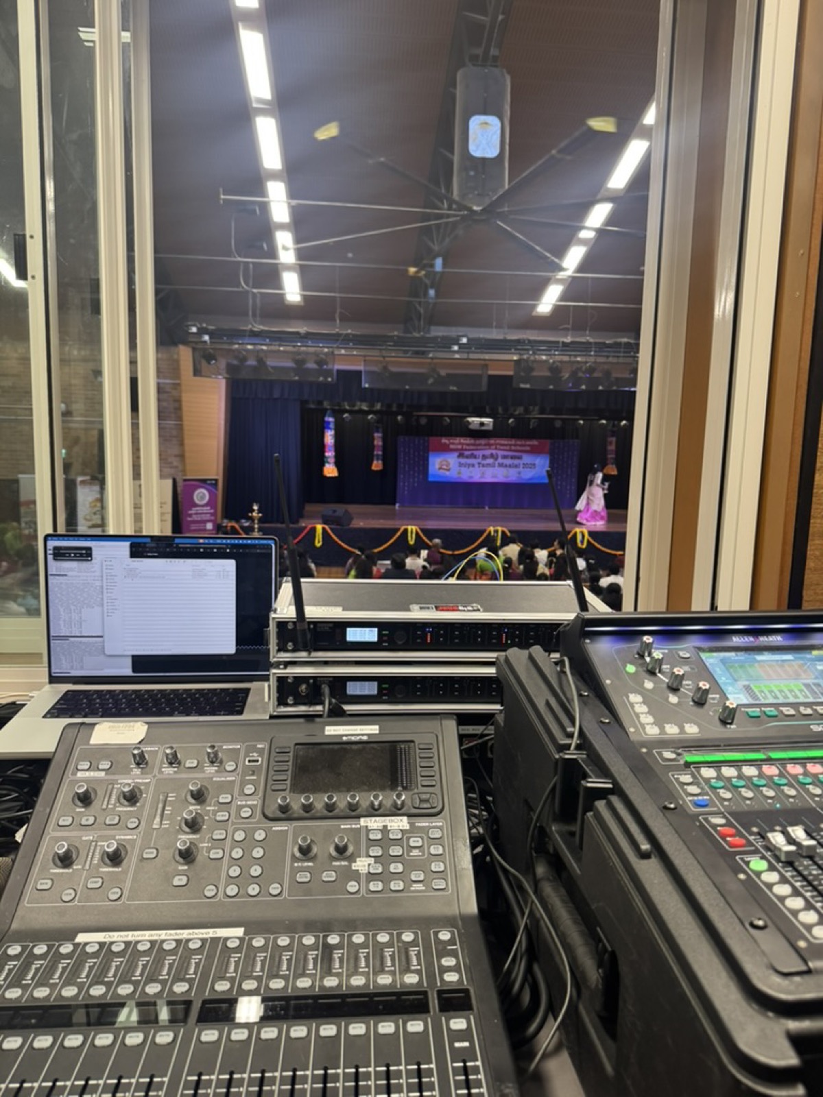 Studio AV's FOH position at a Sydney community cultural event with an Allen and Heath SQ console, Behringer X32 with stagebox, and a MacBook running the show's run sheet